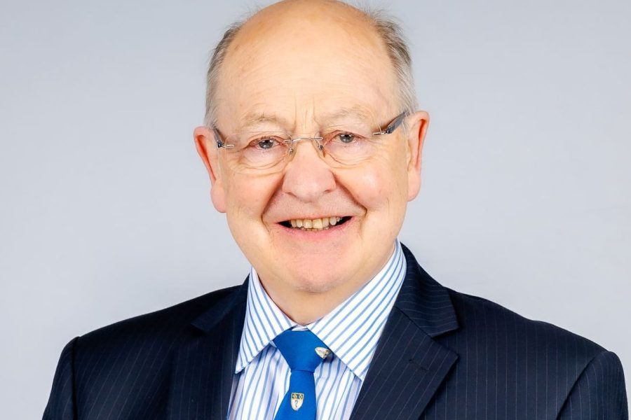 Comisiynydd Bevan, yr Athro Ewan Macdonald yn gwisgo siwt dywyll a thei glas.