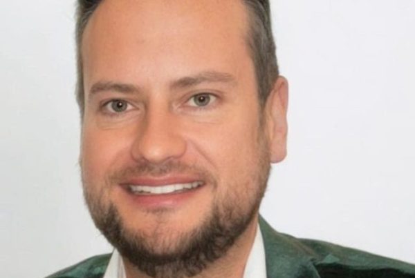 Bevan Fellow Dr Stuart Kyle wearing dark green velvet jacket and white shirt