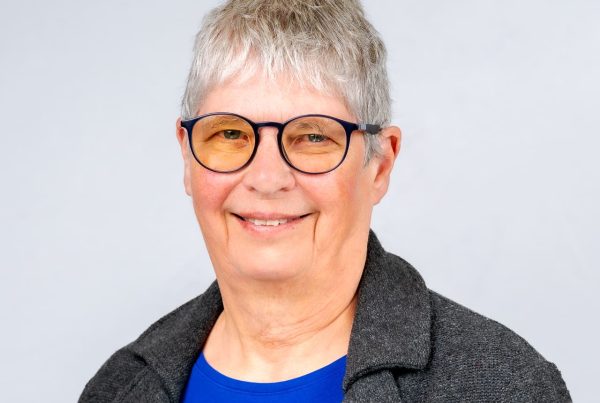 Fran Targett OBE, Bevan Commissioner in a blue top and grey jacket